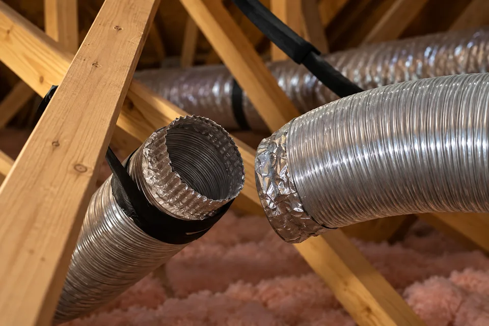 Imagem anonimizada com IA de um duto metálico de ventilação desconectado em um sótão